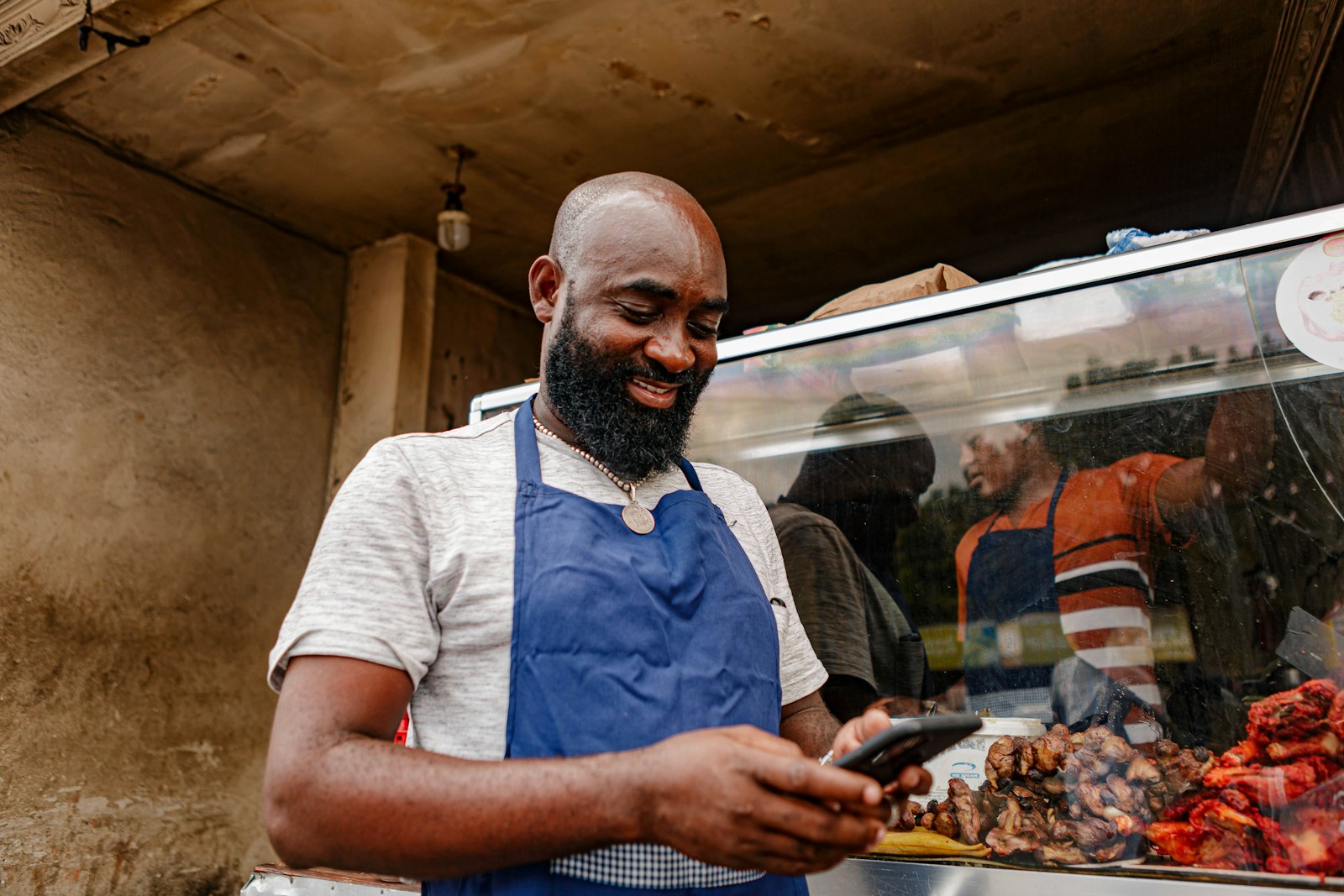 A small business owner using a smartphone at their storefront