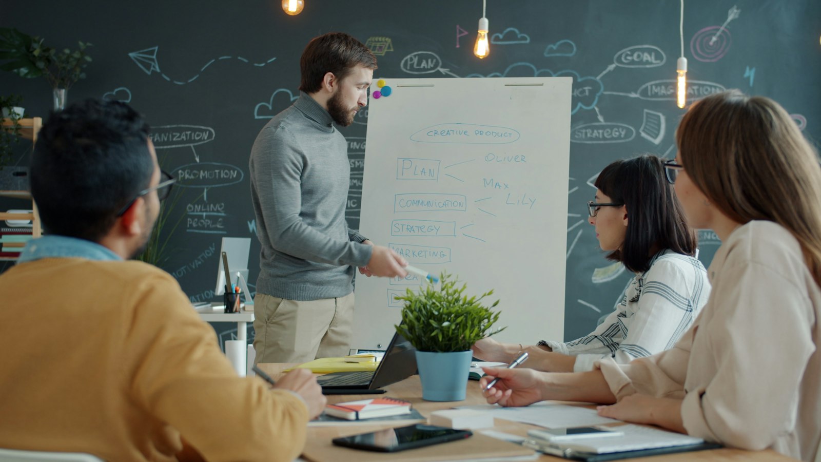 Team collaborating around a whiteboard covered in sticky notes in a modern office