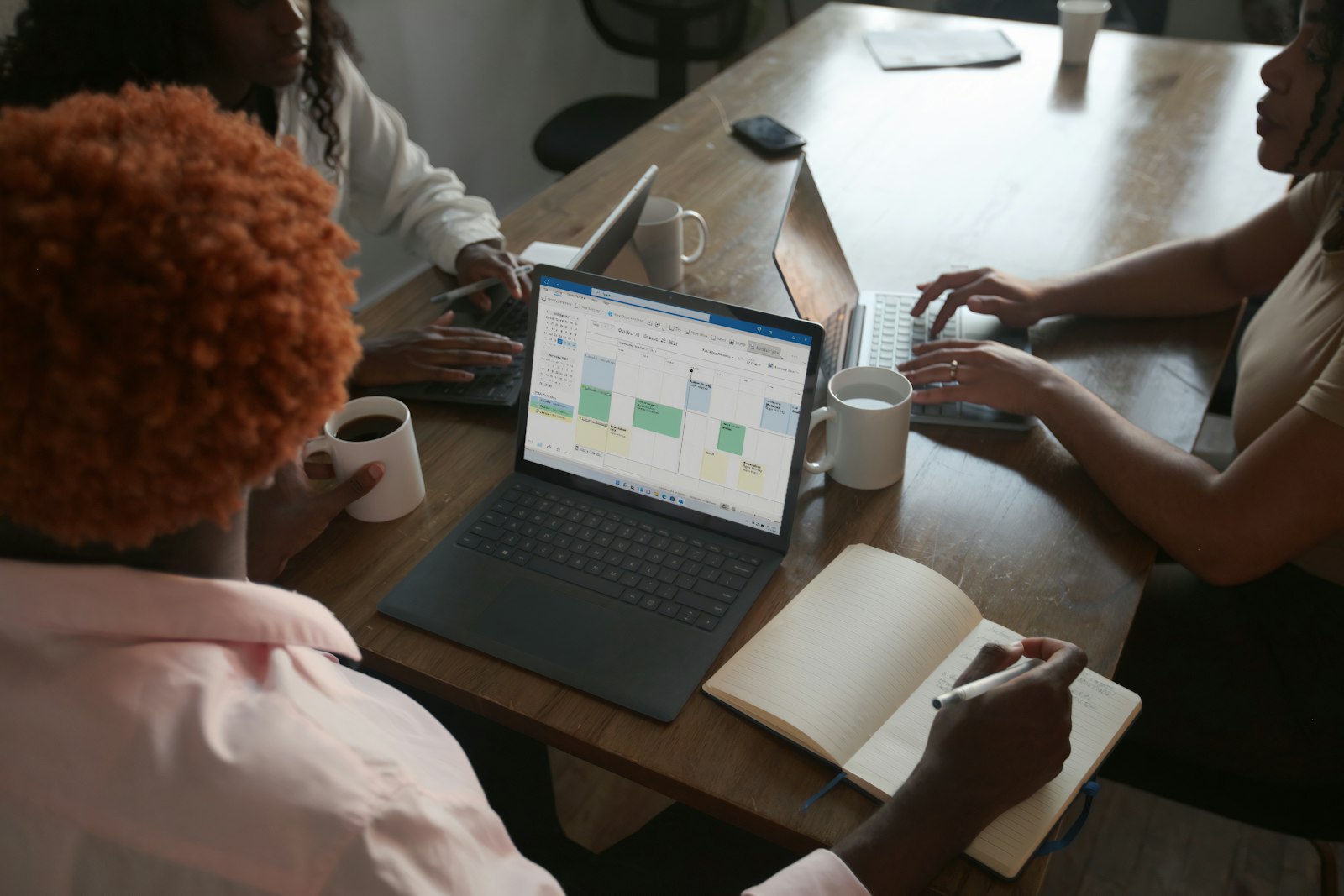 Team discussing a business plan and schedule around a laptop