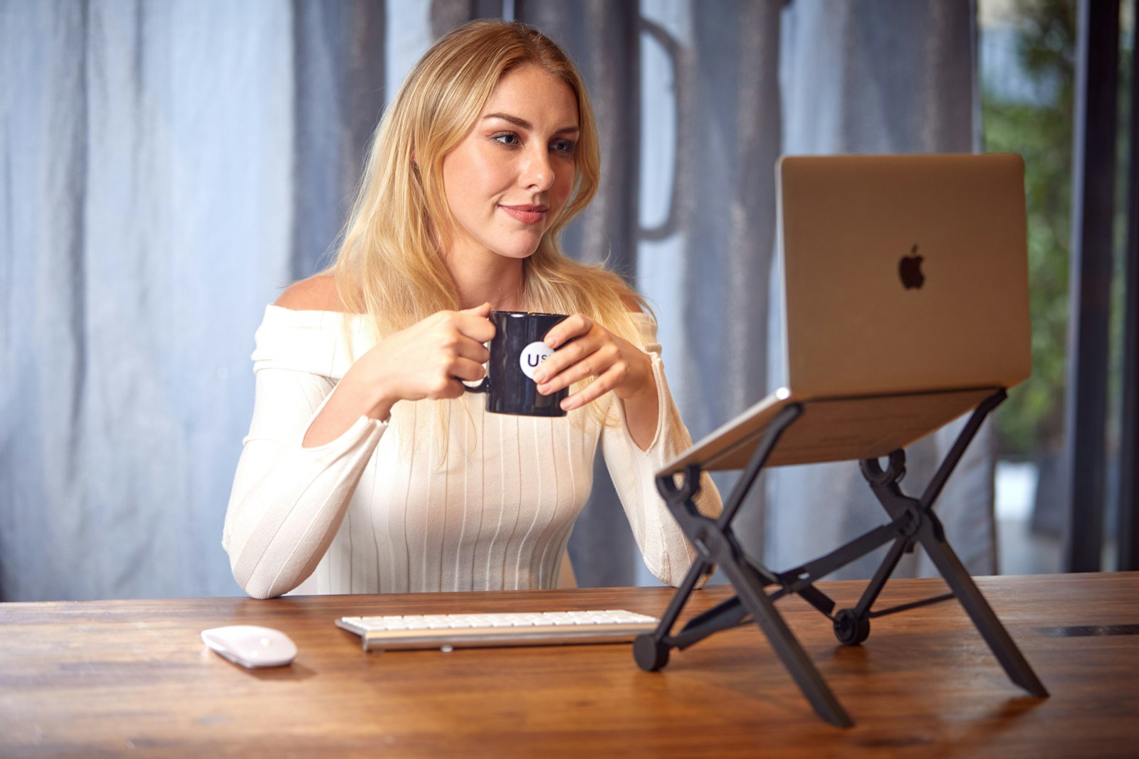 Woman working on a laptop with a cup of coffee