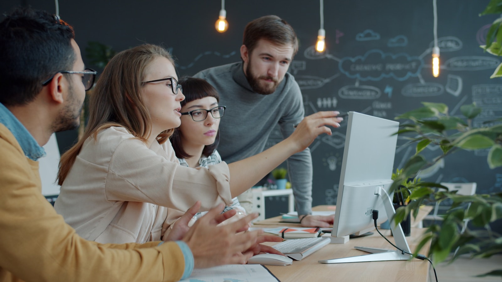 Team collaborating around a laptop in an office setting