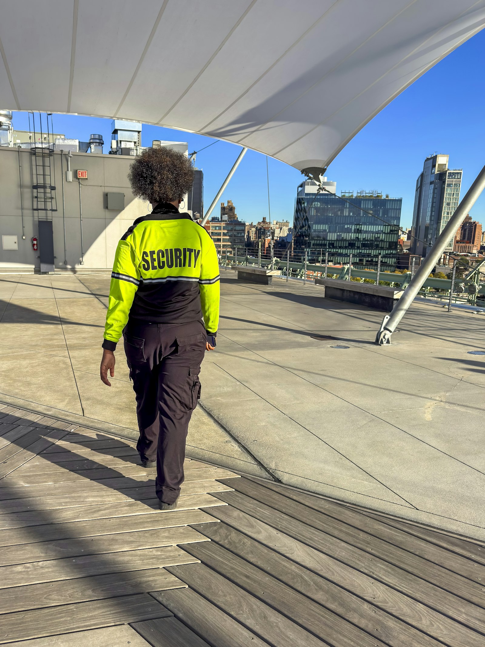 Security professional monitoring a building from a rooftop vantage point
