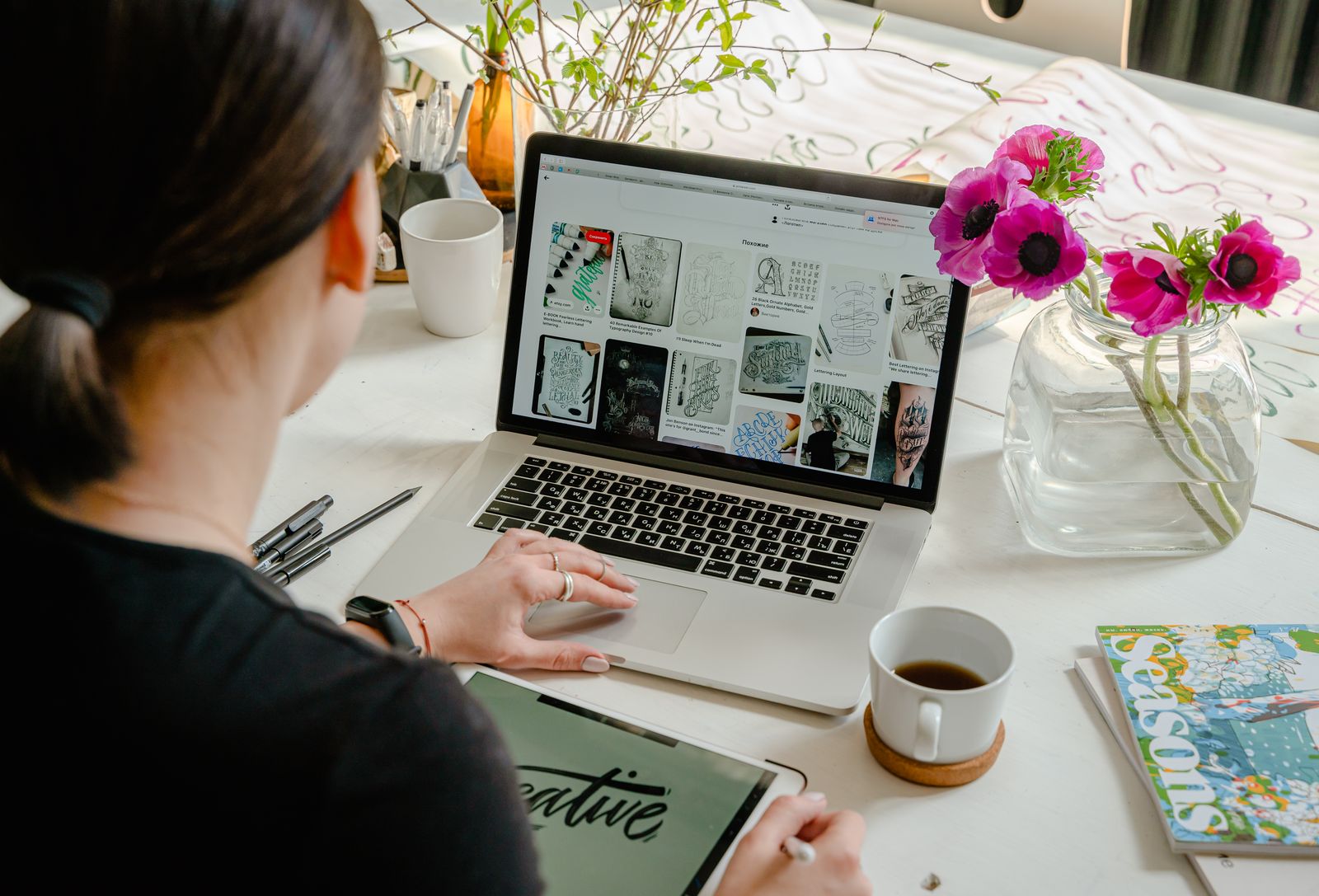 Designer working on a laptop with graphic design tools