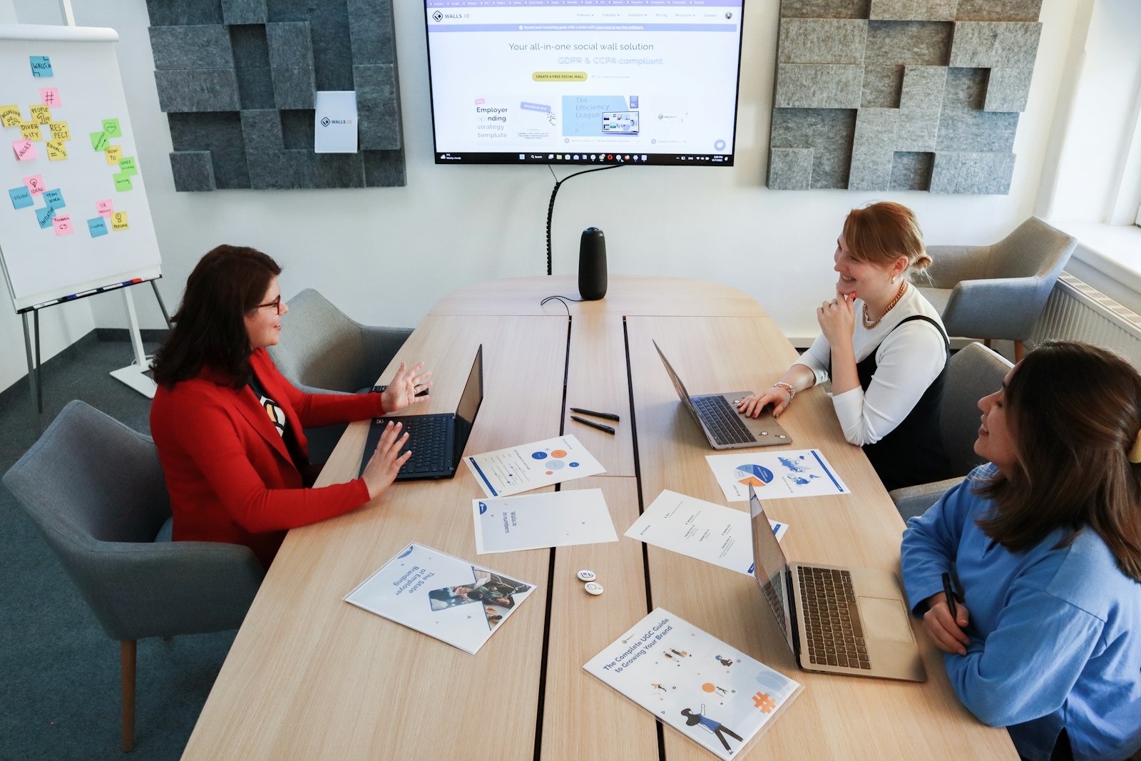 Team collaborating around a table with laptops