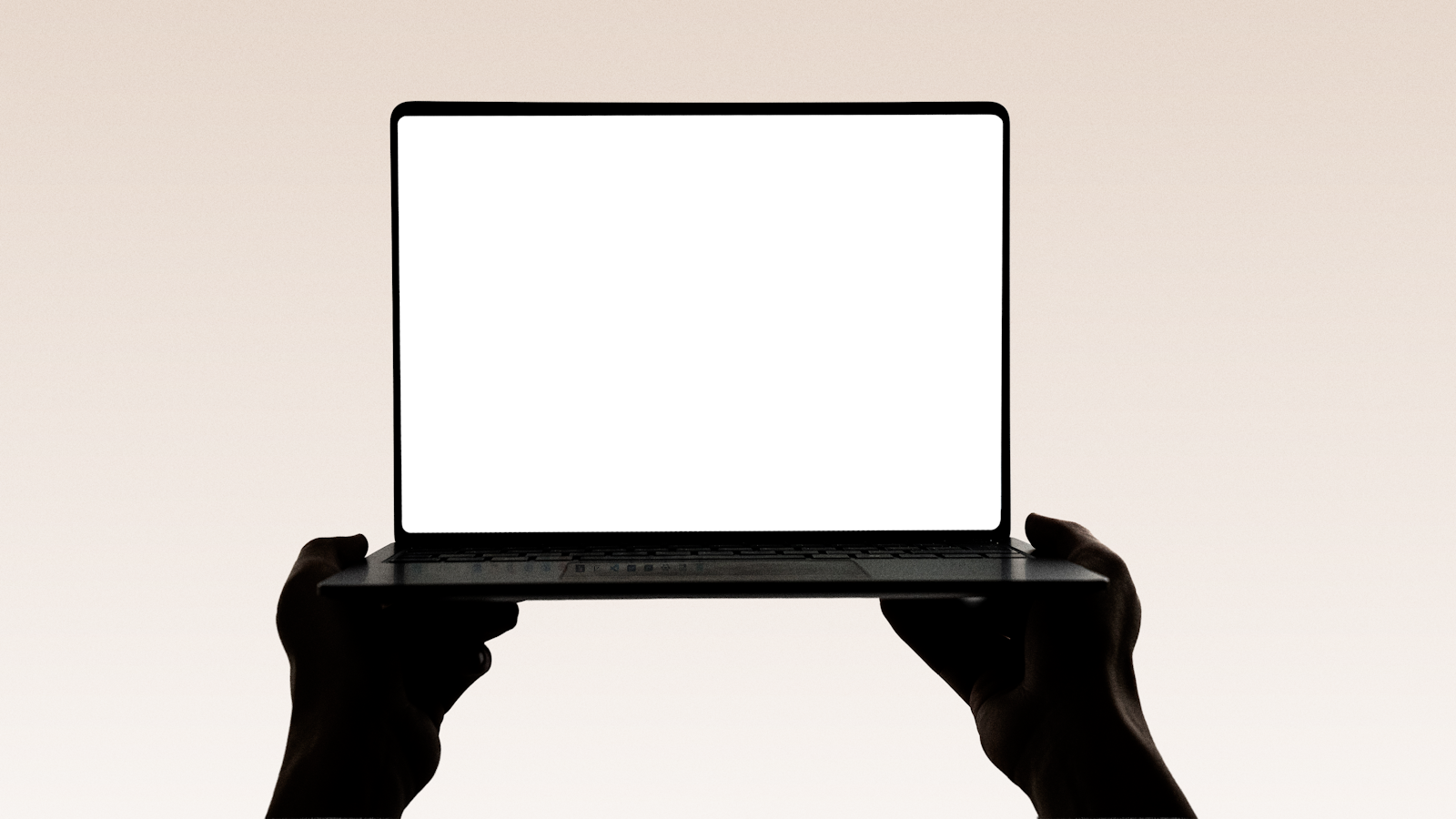 Hands holding up an open laptop displaying a website design
