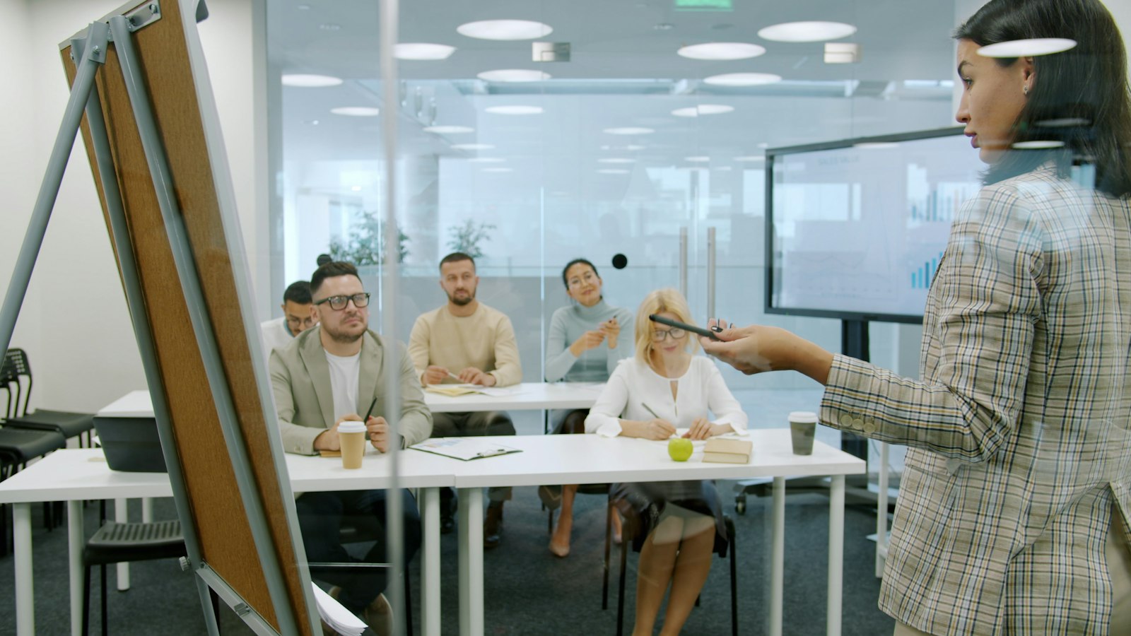 Facilitator presenting to a group of professionals in a modern office